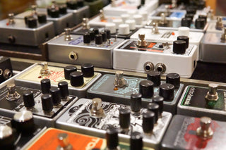 Collection of guitar effect pedals with various knobs and labels.