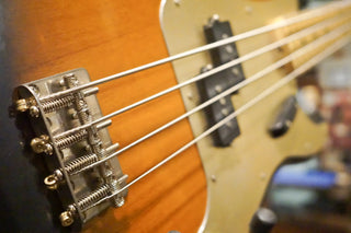 Close-up of strings and pickups on an electric bass