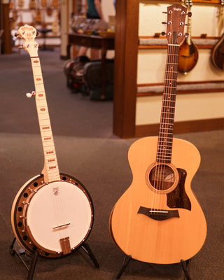 Banjo and steel-string guitar on stands in a music store