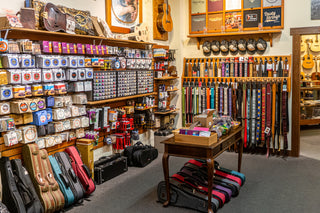 Two walls jam-packed with guitar straps, strings, picks, capos, and other musical instrument accessories