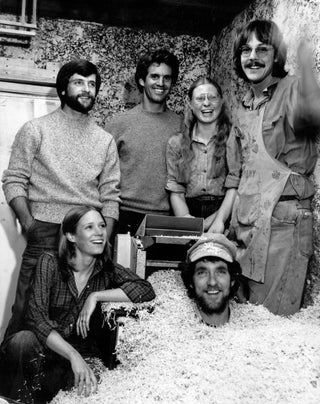 Six smiling people in a basement with a pile of sawdust