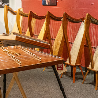 Row of harps with a hammered dulcimer in the foreground