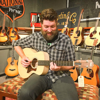 Smiling person playing ukulele