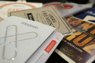 Close-up of guitar string packaging with brand names.