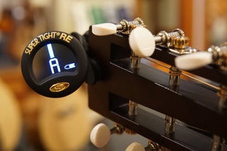 Close-up of a guitar tuner on a guitar headstock.