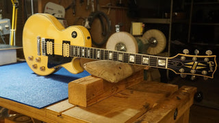 Blonde guitar on a blue workbench