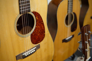Close-up of acoustic guitars with focus on the soundhole and worn finish